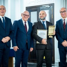 Dr inż. Rafał Hrynyk na zdjęciu z osobami wręczającymi nagrodę