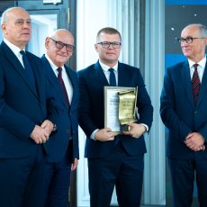Paweł Chabiński na zdjęciu z osobami wręczającymi nagrodę