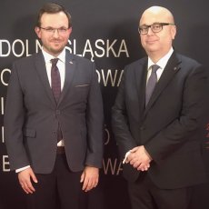 Dr inż. Tomasz Nowobilski oraz Okręgowy Inspektor Pracy we Wrocławiu Andrzej Pogórski stoją na tle ścianki