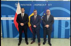 Zdjęcie Sekretarza Stanu z Ministerstwa Pracy i Ochrony Socjalnej Republiki Mołdawii, Zastępcy Głównego Inspektora Pracy oraz Okręgowego Inspektora Pracy we Wrocławiu na tle flag